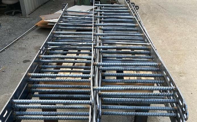 Bundles of rebar rods organized in metal cradle racks on a flatbed trailer for delivery by Valley Nut & Bolt.